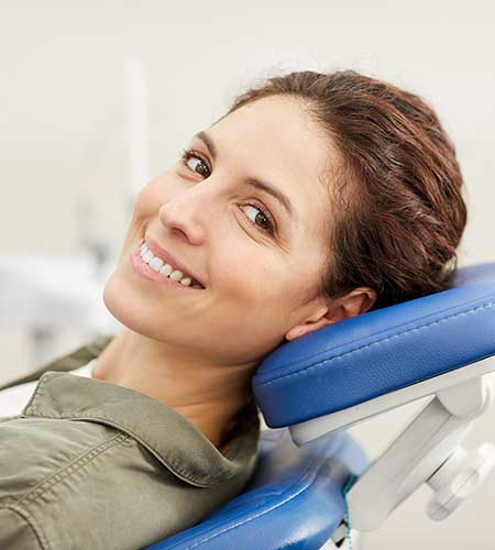 Woman sitting in dental chair with smile.