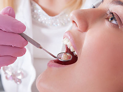 A dental professional is performing a procedure on a patient s mouth using specialized equipment.
